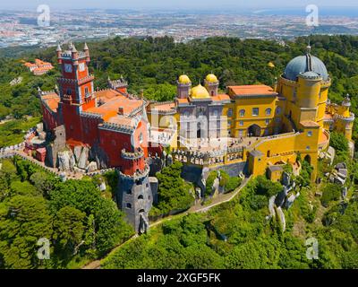 Palazzo colorato con edifici gialli e rossi, cupola e torri, circondato da colline boscose, vista aerea, Palacio Nacional da pena, Palazzo Nazionale Foto Stock