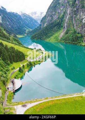Un idilliaco lago di montagna circondato da vegetazione lussureggiante e ripide montagne con un fiume che scorre attraverso di esso, Stilluptal, Austria, Germania Foto Stock
