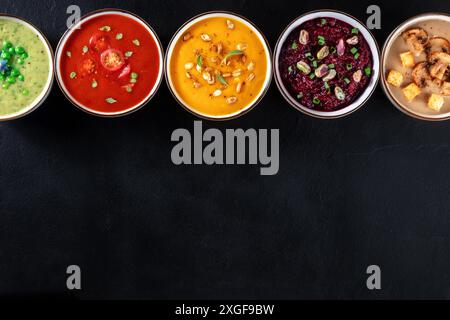 Banner zuppa di crema vegana con spazio per la copia. Un assortimento di zuppe di verdure, sparate dall'alto su sfondo nero Foto Stock