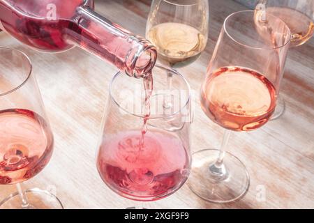 Vino rosato versato in un bicchiere, una degustazione di vino o una festa Foto Stock