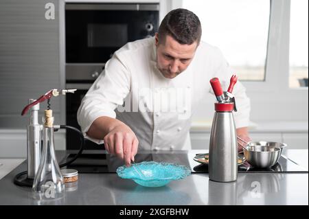 Raffinato ristorante chef preparare piatti deliziosi con sofisticati utensili in cucina commerciale. Foto di alta qualità Foto Stock