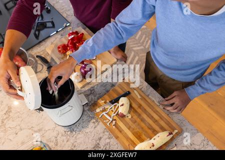 Preparando il pasto, gli uomini sbucciano le patate e scartano gli scarti in cucina Foto Stock