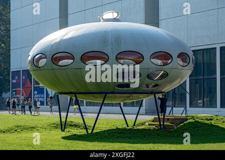 Futuro, futuro House, casa rotonda in plastica di Matti Suuronen, futuristico funzionale, UFO, persone che corrono durante gli esercizi mattutini, prato Foto Stock
