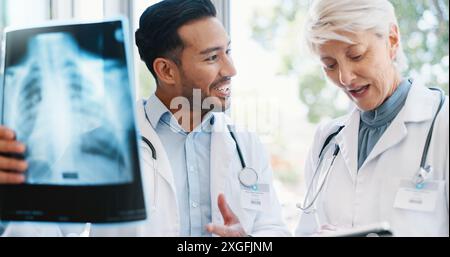 Medici, radiografia e discussione medica in ospedale, professionale e collaborazione per i risultati toracici dei pazienti. Radiologo maturo, tablet e. Foto Stock