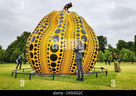 Londra, Regno Unito. 9 luglio 2024. Il visitatore Esther guarda la scultura, vestita con un abito coordinato con molti punti. Questa grande scultura, 'zucca' (2024), realizzata dal giapponese Yayoi Kusama, sarà in situ presso lo stagno rotondo nei giardini di Kensington fino a novembre ed è visitabile liberamente nei giardini. È la più grande scultura di zucca in bronzo di Kusama fino ad oggi. Crediti: Imageplotter/Alamy Live News Foto Stock