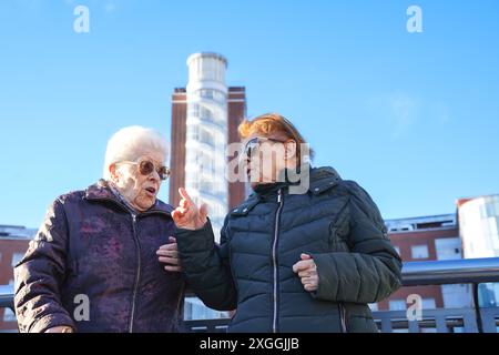 Due signore anziane che indossano occhiali da sole che parlano all'aperto. Sorelle anziane Foto Stock