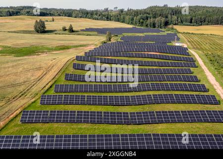 Una grande fattoria solare installata su una collina erbosa. Foto Stock