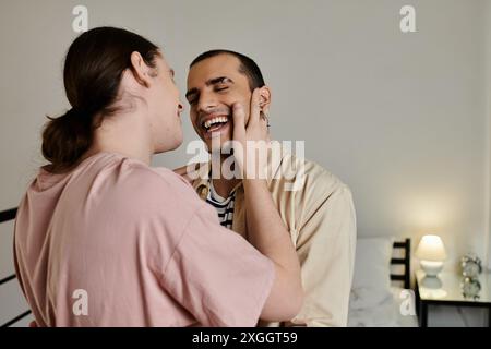 Una giovane coppia gay gode di un momento tenero insieme nel loro appartamento moderno. Foto Stock