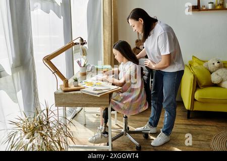 Una madre bruna e sua figlia, che ha una gamba protesica, passano del tempo insieme a casa. Foto Stock