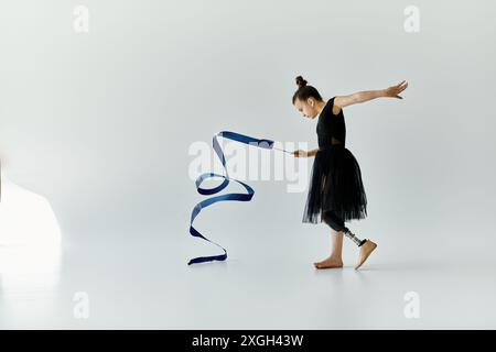 Una giovane ragazza con una gamba protesica esegue una graziosa routine di ginnastica. Foto Stock