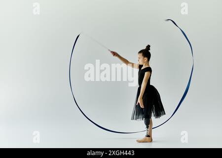 Una giovane ragazza con una gamba protesica esegue una graziosa routine di danza del nastro. Foto Stock