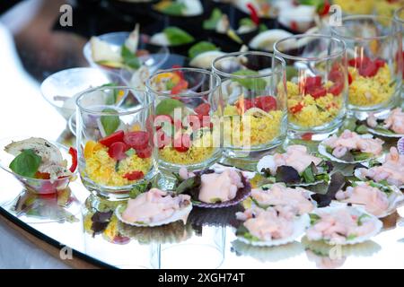 Varietà di colorati antipasti nuziali esposti su un tavolo di vetro, perfetti per un ricevimento di nozze Foto Stock