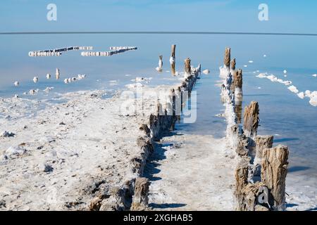 Antiche rovine di bagni di sale e un molo di legno in una giornata di sole. Lago salato Elton. Regione di Volgograd, Russia Foto Stock