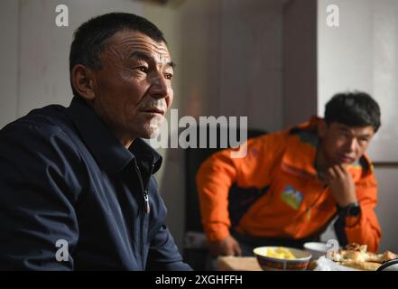 (240709) -- AKTO, 9 luglio 2024 (Xinhua) -- Taxibayi Janibaiki e suo padre Janibaiki Burunbayi (L) riposano a casa ad Akto, nella regione autonoma Xinjiang Uygur della Cina nord-occidentale, 5 luglio 2024. Il Muztagh Ata, situato sull'altopiano di Pamir a un'altitudine di oltre 7.500 metri nella regione autonoma di Xinjiang Uygur, nella Cina nord-occidentale, è un'attrazione per gli appassionati di alpinismo provenienti da tutto il mondo. Durante la stagione delle arrampicate, la gente si riunisce nel villaggio di Subax, nella contea di Akto, ai piedi del Muztagh Ata per l'alpinismo. Per quanto riguarda le persone locali che hanno familiarità con il terreno e il clima qui, par Foto Stock