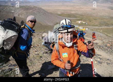 (240709) -- AKTO, 9 luglio 2024 (Xinhua) -- salendo la montagna, Taxibayi Janibaiki (R) e i suoi compagni discutono sul percorso per salire sulla montagna nella regione autonoma Xinjiang Uygur del nord-ovest della Cina, 4 luglio 2024. Il Muztagh Ata, situato sull'altopiano di Pamir a un'altitudine di oltre 7.500 metri nella regione autonoma di Xinjiang Uygur, nella Cina nord-occidentale, è un'attrazione per gli appassionati di alpinismo provenienti da tutto il mondo. Durante la stagione delle arrampicate, la gente si riunisce nel villaggio di Subax, nella contea di Akto, ai piedi del Muztagh Ata per l'alpinismo. Per quanto riguarda quelle persone locali che sono fami Foto Stock