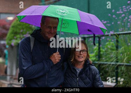 9 luglio 2024; All England Lawn Tennis and Croquet Club, Londra, Inghilterra; Wimbledon Tennis Tournament, 9° giorno; gli spettatori di Wimbledon cercano di mantenersi asciutti sotto la forte pioggia Foto Stock