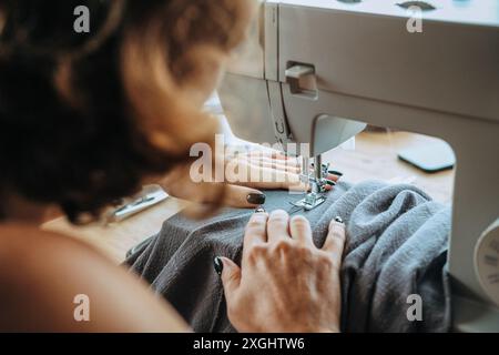 Il lavoro di un sarto professionista in un atelier. Sartoria di vestiti su ordinazione. Foto Stock