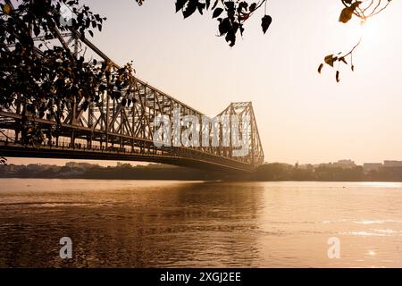 Il fiume Hooghly e l'iconico ponte Howrah a Calcutta sono visibili al mattino all'alba. Esempio di architettura indiana a Kolkata Foto Stock