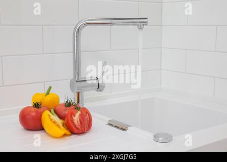 L'acqua fuoriesce dal rubinetto in primo piano nell'interno della cucina Foto Stock