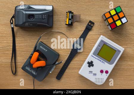 Tecnologia anni '1990 retro 1980, tra cui Sony WALKMAN ®, Nintendo Game Boy, orologio digitale Casio e Canon camera, con il cubo di Rubik Foto Stock