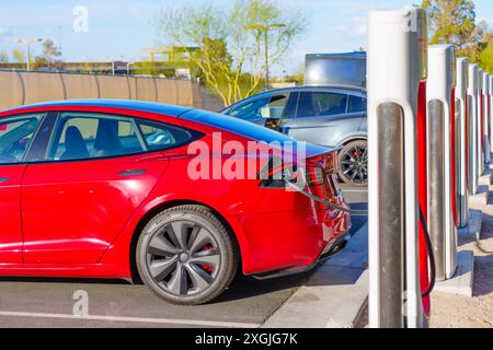 Los Angeles, California - 15 aprile 2024: La Tesla Model S rossa e un'altra auto elettrica si caricano fianco a fianco presso la stazione Supercharger Tesla in California Foto Stock