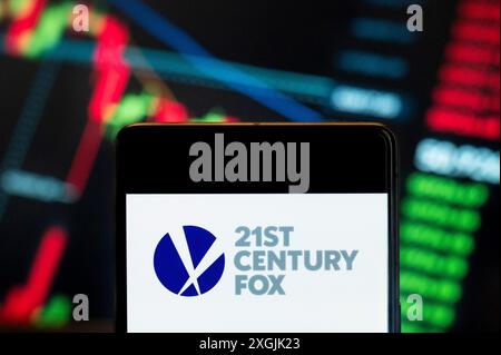 In questa illustrazione fotografica, il logo della multinazionale americana dei mass media Twenty-first 21st Century Fox visto su uno smartphone con un grafico dell'indice di borsa sullo sfondo. Foto Stock