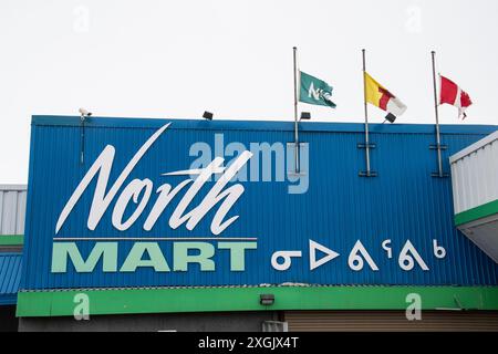 Insegna bilingue per i grandi magazzini North Mart in inglese e Inuktitut sulla Queen Elizabeth Way a Iqaluit, Nunavut, Canada Foto Stock