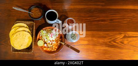 Delizioso piatto di tradizionale pozolo rosso messicano con ravanello, lattuga, ominide, maiale e peperoncino secco. Accompagnato da caffè, salsa rossa messicana, tosta Foto Stock