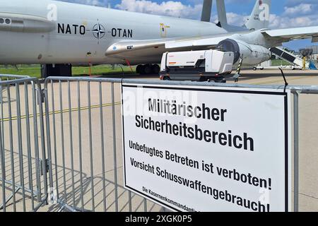 Schönefeld, Brandeburgo, Deutschland, 07.06.2024: ExpoCenter-Aeroporto: Internationale Luft- und Raumfahrtausstellung Berlin ILA: DAS Airborne Early Warning and Control System, kurz AWACS ist ein fliegendes Radarsystem der NATO auf Basis einer modifizierter Boeing 707-Maschine. Im Vordergrund steht ein Schild mit der Aufschrift: Militärischer Sicherheitsbereich - Unbefugtes Betreten ist verboten Vorsicht Schusswaffengebraucht die NATO betreibt auf der Air base Geilenkirchen eine flotte von derzeit 14 dieser Maschinen. Die Bordbesatzung der AWACS besteht in der Regel aus 16 Soldaten verschiedener Foto Stock