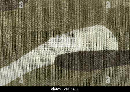 Primo piano di un pezzo di tessuto mimetico. Il tessuto è un mix di marrone e bianco, con un motivo che ricorda un design mimetico. Foto Stock