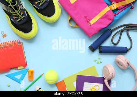 Telaio realizzato con scarpe da ginnastica, corda da salto, palla da tennis, cuffie e diversi articoli di cancelleria su sfondo blu Foto Stock