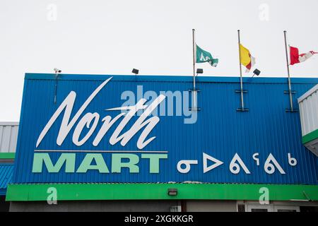 Insegna bilingue per i grandi magazzini North Mart in inglese e Inuktitut sulla Queen Elizabeth Way a Iqaluit, Nunavut, Canada Foto Stock