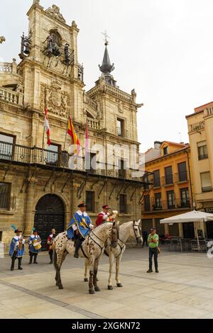 Astorga, Spagna - 3 giugno 2023: Due uomini a cavallo, vestiti di abiti storici, passano davanti al Consiglio comunale di Astorga, evocando lo spirito di Napoleone. Foto Stock