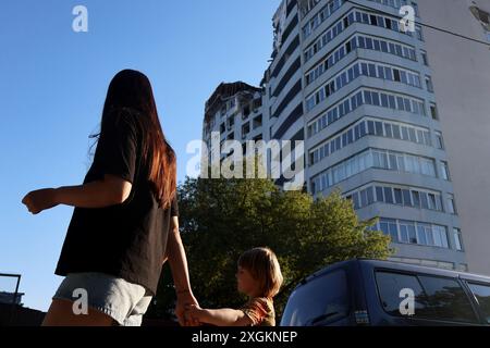 Kiev, Ucraina. 9 luglio 2024. I residenti locali sono visti vicino a un edificio residenziale di cinque piani nel quartiere Holosiivskyi distrutto da un attacco missilistico russo a Kiev. La mattina, l'esercito russo ha effettuato un attacco missilistico di massa alle città ucraine di Kiev, Dnipro, Kryvyi Rih, Sloviansk, Kramatorsk, utilizzando più di 40 missili di vario tipo. A Kiev, edifici residenziali, infrastrutture e ospedale per bambini "Okhmatdyt" sono stati danneggiati. I soccorritori continuano a cercare persone sotto le macerie. Credito: SOPA Images Limited/Alamy Live News Foto Stock