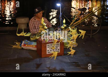 Hoi An, Vietnam 7 luglio 2024: Il falegname vende la cavalletta, fatta dalla tessitura dell'erba. la tessitura dell'erba è un'abilità tradizionale di tessitura artistica. Foto Stock