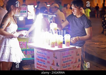 Hoi An, Vietnam 7 luglio 2024: hawker vende la bevanda fredda al turista nel mercato notturno di Hoi An. la città vecchia è un porto commerciale che risale dal 15 al 15 Foto Stock