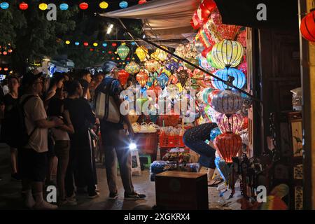 Hoi An, Vietnam 7 luglio 2024: hawker vende le lanterne ai turisti del mercato notturno di Hoi An. la città vecchia è un porto commerciale che risale dal 15 al 19 Foto Stock