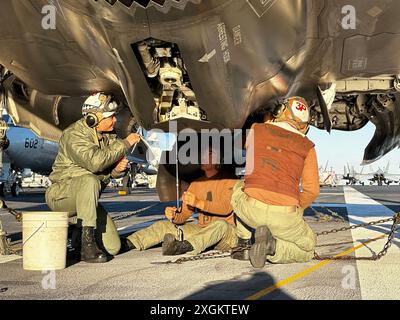 U.S. Marine Corps Gunnery Sgt. Christopher Goad, a destra, capo della divisione Powerline con Marine Fighter Attack Squadron 314, Marine Aircraft Group 11, 3rd Marine Aircraft Wing, e i Marines con VMFA 314, conducono la manutenzione su un F-35B Lightning II, a bordo della portaerei classe Nimitz USS Abraham Lincoln (CVN-72), 11 febbraio 2024. Goad, presidente del club motociclistico VMFA-314, è stato insignito della Navy and Marine Corps Commendation Medal per aver fornito aiuti salvavita a un altro pilota motociclistico il 21 aprile 2024. (Foto di cortesia del corpo dei Marines degli Stati Uniti) Foto Stock