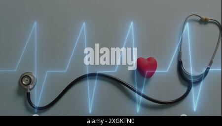Immagine del montiore della frequenza cardiaca rispetto al primo piano dello stetoscopio e al cuore rosso su una superficie grigia Foto Stock