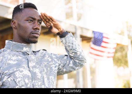 Soldato afroamericano in uniforme che saluta all'aperto, copia spazio. Servizio militare, esercito, lavoro, attenzione e dovere, inalterati. Foto Stock