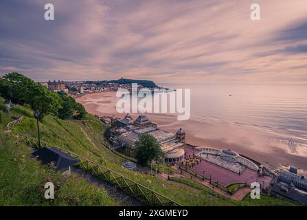 Scarborough South Bay poco dopo l'alba. Il punto panoramico in cima alla scogliera offre vedute dei giardini sulla scogliera, del centro termale, della spiaggia, del Castle Headland e del porto Foto Stock