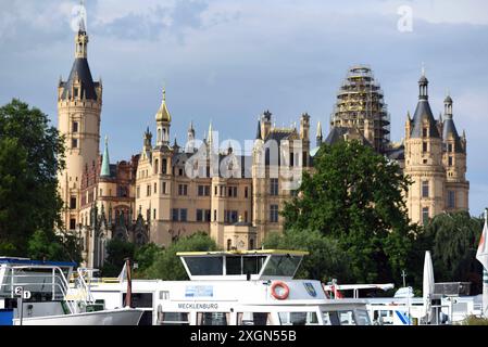 Schwerin, Germania. 10 luglio 2024. Le barche passeggeri sono ormeggiate sul lago Schwerin di fronte al castello della capitale dello stato. Il servizio meteorologico tedesco ha annunciato nuovi temporali. Crediti: Frank Hormann/dpa/Alamy Live News Foto Stock