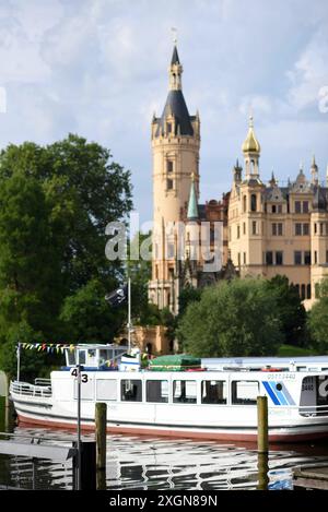 Schwerin, Germania. 10 luglio 2024. Le barche passeggeri sono ormeggiate sul lago Schwerin di fronte al castello della capitale dello stato. Il servizio meteorologico tedesco ha annunciato nuovi temporali. Crediti: Frank Hormann/dpa/Alamy Live News Foto Stock