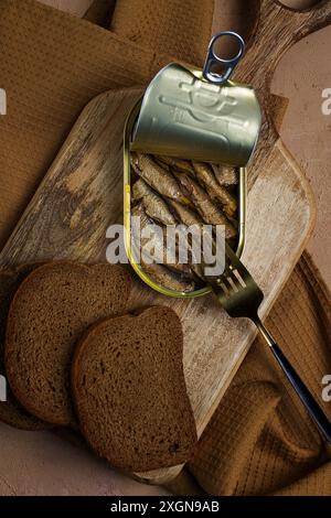 Spratti nel burro, con pane nero, pesce affumicato in scatola, aperto, primo piano, vista dall'alto, niente persone Foto Stock