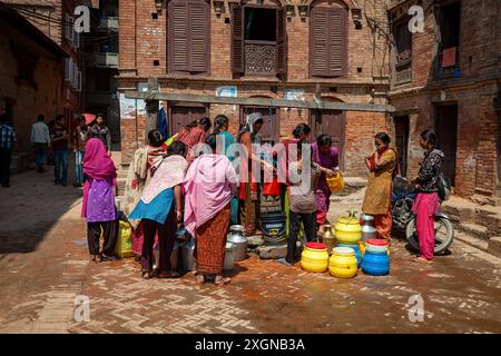 Le donne prendono l'acqua dal pozzo di Bhaktapur Foto Stock