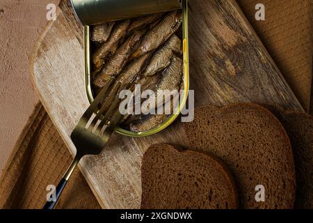 Spratti nel burro, con pane nero, pesce affumicato in scatola, aperto, primo piano, vista dall'alto, niente persone Foto Stock