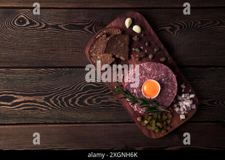 Tartare di manzo, con uova, capperi, cetriolini e pane, tonico, vista dall'alto, primo piano, orizzontale, nessuna persona Foto Stock