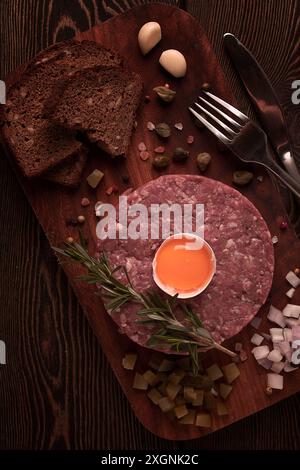 Tartare di manzo, con uova, capperi, cetriolini e pane, tonico, vista dall'alto, primo piano, orizzontale, nessuna persona Foto Stock