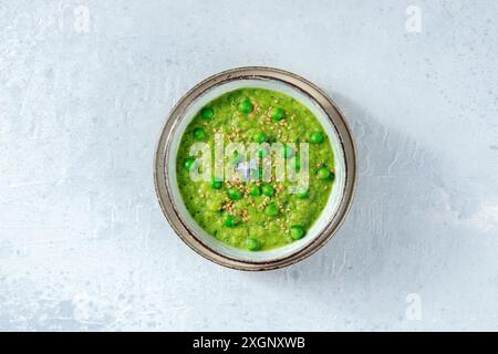 Zuppa vegana, sparata dall'alto, con piselli verdi e semi di sesamo Foto Stock