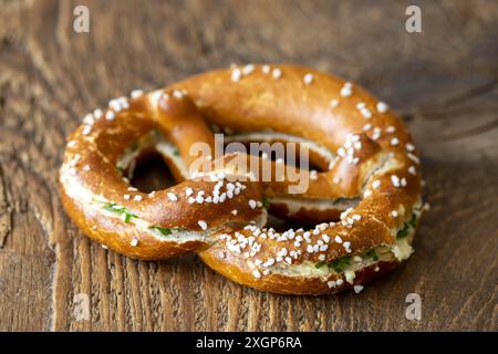 Pretzel bavarese con burro su legno Foto Stock